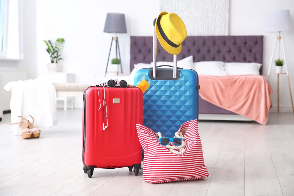 Colorful travel bags packed and ready in a hotel room, representing vacation packages or holiday tours from Bangladesh to international destinations like the Maldives